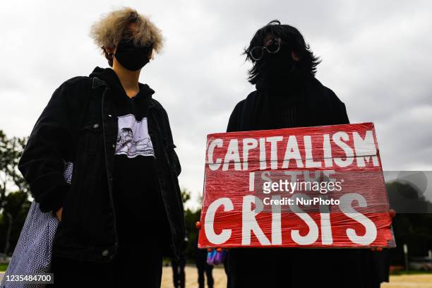 Woman holds a banner 'Capitalism Is the Crisis' during Climate Strike protest organized by Fridays for Future movement also known as Youth Strike for...