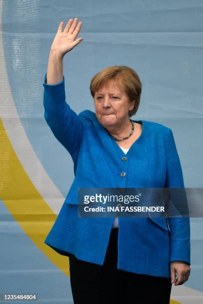 German Chancellor Angela Merkel waves as she stands on stage during a campaign rally for Christian Democratic Union CDU leader and chancellor...