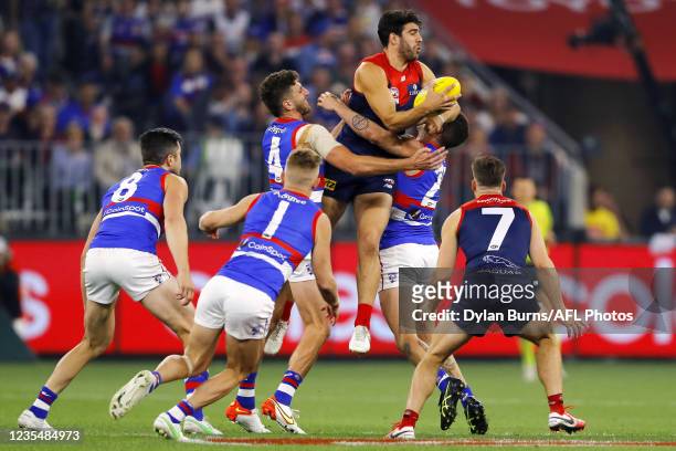 Christian Petracca of the Demons is tackled by Tom Liberatore of the Bulldogs and Marcus Bontempelli of the Bulldogs during the 2021 Toyota AFL Grand...