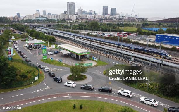 An aerial view shows customers queueing in their cars to access an Asda petrol station in east London on September 25, 2021. - The UK government is...