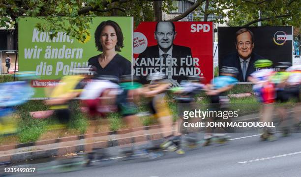 Skaters taking part in the In-line Skating event of the Berlin Marathon speed past election campaign posters showing the three chancellor candidates...