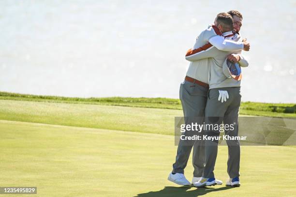 Sergio Garcia and Jon Rahm of Spain and and Team Europe celebrate and hug after their 3&1 victory on the 17th hole green during Saturday Morning...