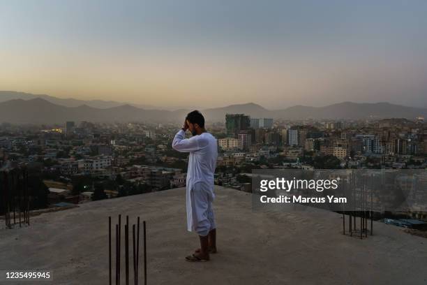 Azim Rahimi stands over the construction site of his family home, which has been under construction for the more than 20 years, due to constant...