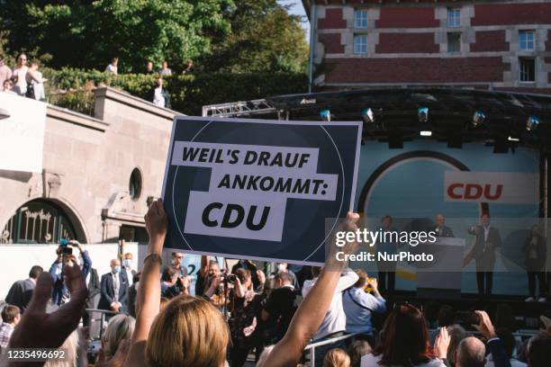 A woman holds an election placard during the Christian Democratic Union candidate Armin Laschet and German Chancellor Angela Merkel election campaign...