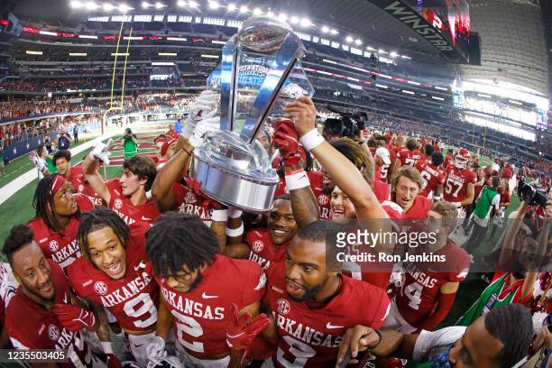 The Arkansas Razorbacks celebrate with the Southwest Classic championship trophy following the teams 20-10 win over Texas A&M Aggies at AT&T Stadium...