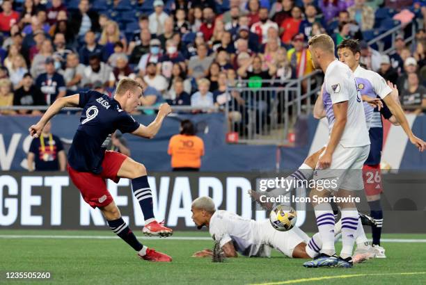 New England Revolution forward Adam Buksa has his shot blocked by Orlando City SC defender Rodrigo Schlegel during a match between the New England...