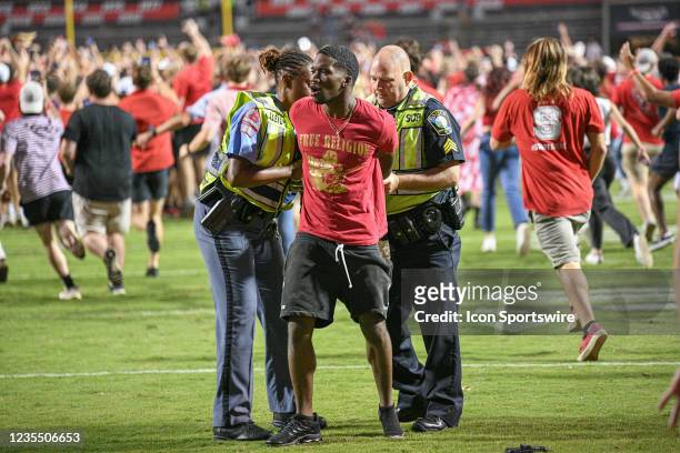 Fan is arrested after rushing the field after the game between the Clemson Tigers and the NC State Wolfpack on September 25, 2021 at Carter-Finley...
