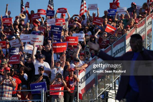 Republican Senate candidate Herschel Walker walks off the stage as a crowd cheers during a rally featuring former US President Donald Trump on...