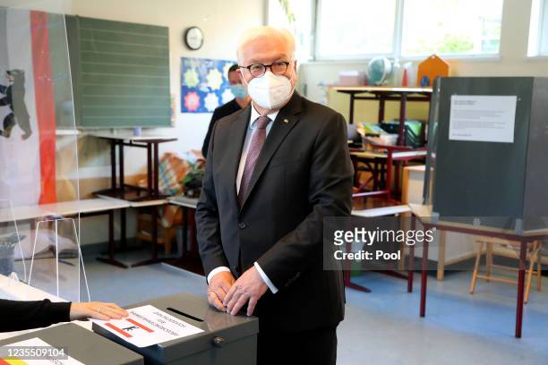German President Frank-Walter Steinmeier reacts after casting his vote for the general election, at a polling station on September 26, 2021 in...