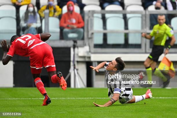 Juventus' Argentine forward Paulo Dybala and Sampdoria's Gambian defender Omar Colley fall after colliding during the Italian Serie A football match...