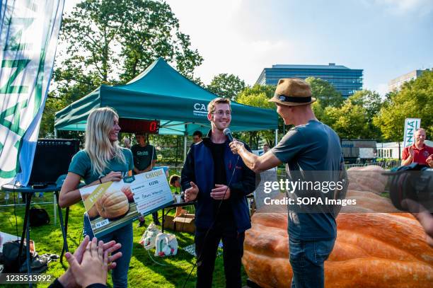 Farmer is seen receiving the prize with his giant pumpkin behind him. During the Dutch Championship, participants of different giant vegetables...