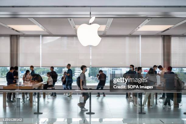 Shoppers are seen at the American multinational technology company Apple store and logo on the first weekend after the launch of the new iPhone 13...