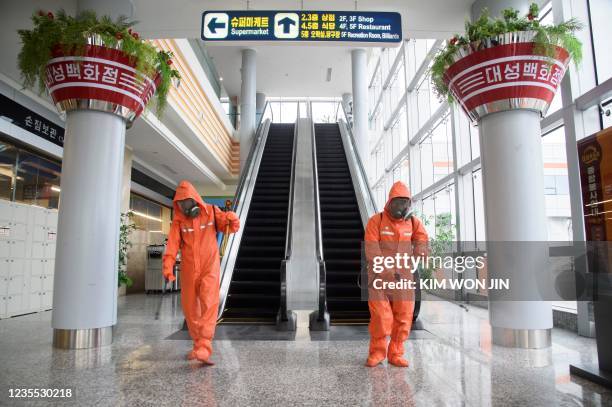 Health officials spray disinfectant as part of preventative measures against Covid-19, in the Daesong Department Store in Pyongyang on September 27,...