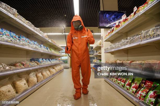 Health official sprays disinfectant as part of preventative measures against Covid-19, in the Daesong Department Store in Pyongyang on September 27,...