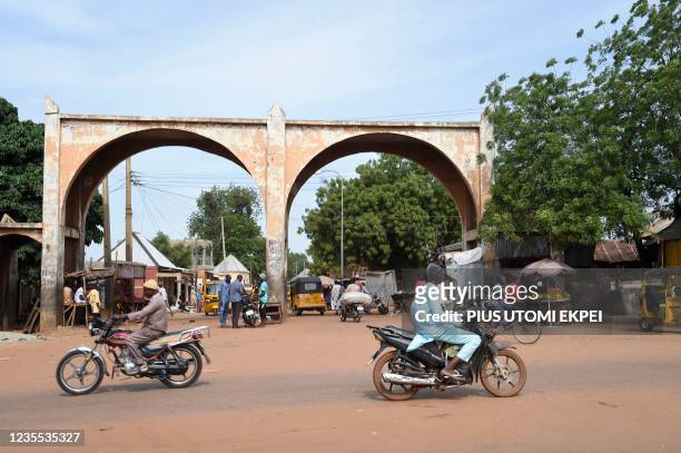 Motor bike riders drive past Kofar Kade, a city gate in ancient Sokoto, northwest Nigeria on September 21, 2021. - On one of the routes taken by the...