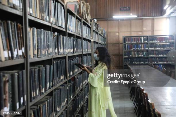 Student choose a book wears protective mask inside the library of the Dhaka University during the reopening of Educations institutes. Dhaka...