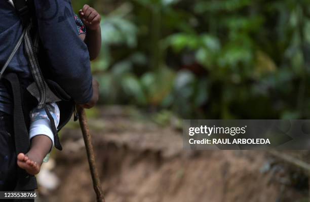 Haitian migrant carries a toddler while crossing the jungle of the Darien Gap, near Acandi, Choco department, Colombia, heading to Panama, on...