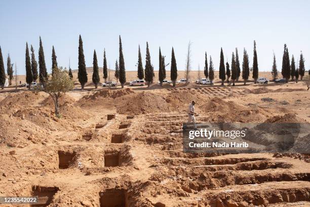 An inspector walks through the mass grave site in a large agricultural area known as Mashrou al-Rabet in Meji on September 27, 2021 in Tarhuna,...