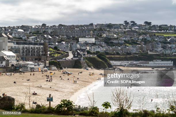 Holiday makers on the beach in St Ives, Cornwall. St Ives is one of the most famous towns in Cornwall England. Every summer holiday makers flock to...