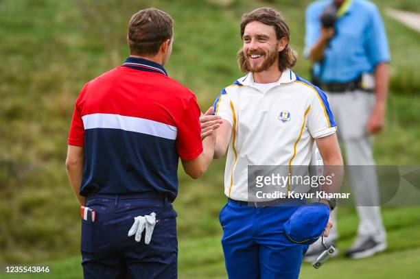 Tommy Fleetwood of England and Team Europe smiles as he greets Jordan Spieth of the U.S. Team following their match during Sunday Singles Matches of...