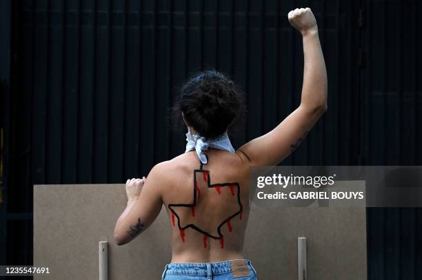 Femen activist with the US state of Texas drawn on her back protests against the new abortion law in Texas in front of the US consulate in Madrid on...