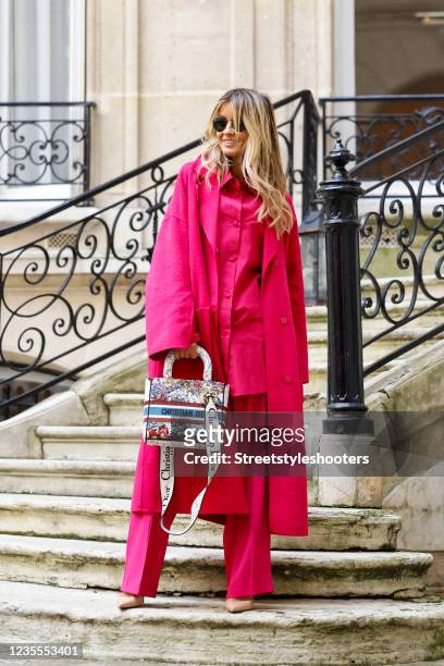 Influencer Gitta Banko wearing a pink monochrome look with an oversized pink coat by Riani, an oversized pink blouse by Riani, wide leg pink pants by...