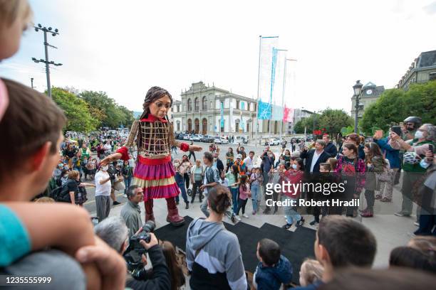Little Amal", a 3.5 meter tall puppet, walks with the help of technicians towards the Grand Theatre de Geneve on September 28, 2021 in Geneva,...