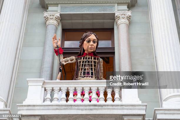 Little Amal", a 3.5 meter tall puppet greets fans from the first floor of the Grand Theatre de Geneve on September 28, 2021 in Geneva, Switzerland....