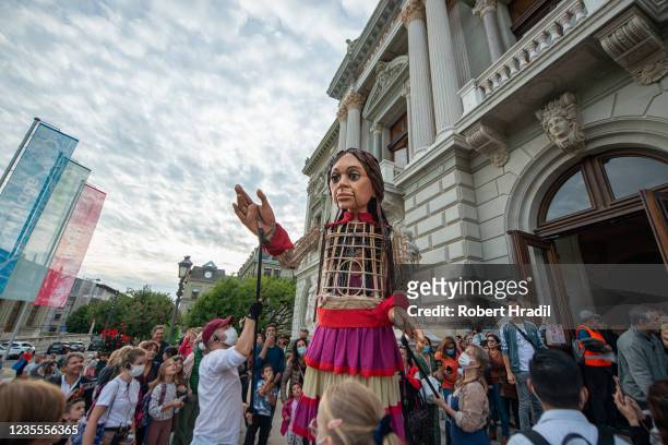 Little Amal", a 3.5 meter tall puppet, walks with the help of technicians towards the Grand Theatre de Geneve on September 28, 2021 in Geneva,...