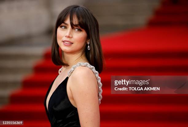 Cuban actor Ana de Armas poses on the red carpet after arriving to attend the World Premiere of the James Bond 007 film "No Time to Die" at the Royal...