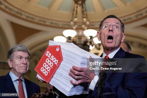 Sen. John Barrasso holds up a visual aide to represent the Democrats' $3.5 trillion budget reconciliation package as he speaks to reporters after a...