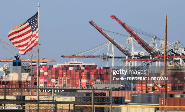 Flag flies near containers stacked high on a cargo ship at the Port of Los Angeles on September 28, 2021 in Los Angeles, California. A record number...