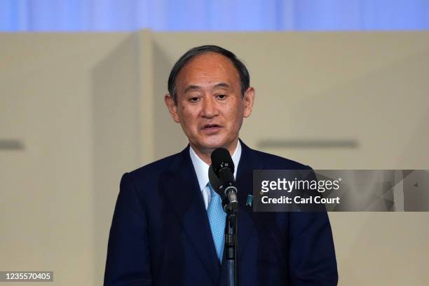 Japanese outgoing Prime Minister Yoshihide Suga speaks before former Japanese Foreign Minister Fumio Kishida takes to the stage following his win in...