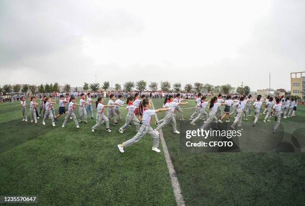 Photo taken on September 29, 2021 shows students performing martial arts gymnastics at a playground in Suqian City, Jiangsu Province, China.