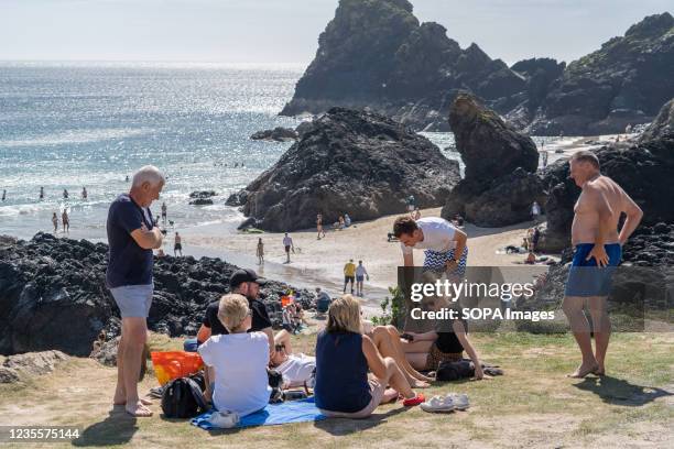 Group of people enjoying the cafe area at Kynance Cove in Cornwall. Kynance Cove is a favourite holiday destination in Cornwall. The Cove boasts...