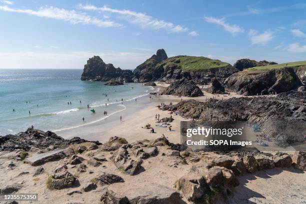 Holiday makers enjoy the beach at Kynance Cove in Cornwall. Kynance Cove is a favourite holiday destination in Cornwall. The Cove boasts clear blue...