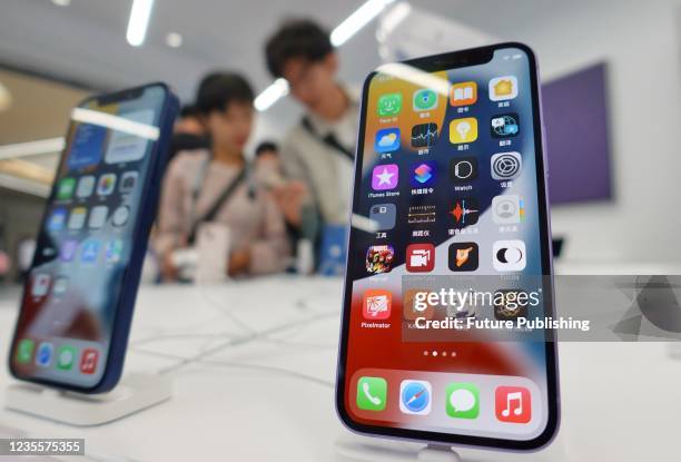 People try the Apple iPhone handsets in a shop in Yantai in east China&#039;s Shandong province Wednesday, Sept. 29, 2021.
