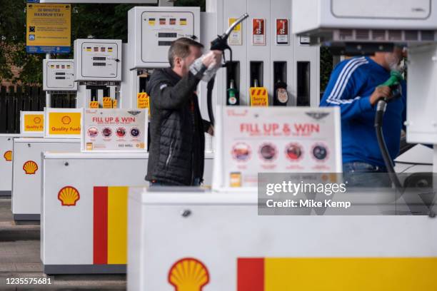 As the fuel crisis in the UK continues, this Shell petrol station is open for business, and motorists drive in with their cars to fill up with fuel,...