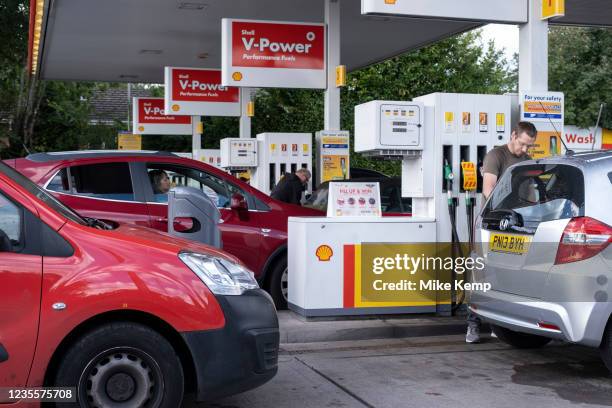 As the fuel crisis in the UK continues, this Shell petrol station is open for business, and motorists drive in with their cars to fill up with fuel,...