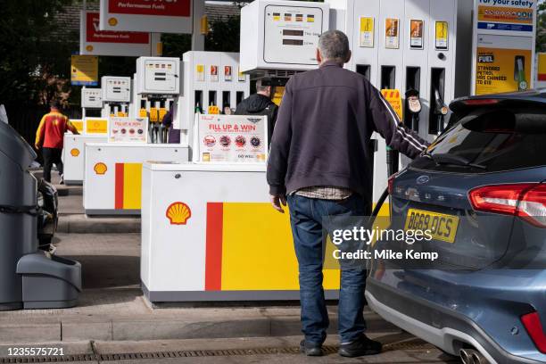 As the fuel crisis in the UK continues, this Shell petrol station is open for business, and motorists drive in with their cars to fill up with fuel,...