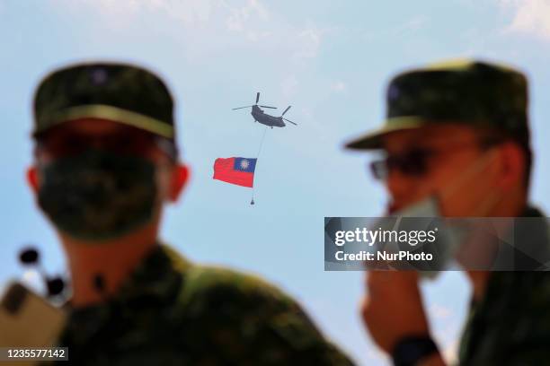 Chinook Helicopter carrying a tremendous Taiwan flag flies over a military camp, as part of a rehearsal for the flyby performance for Taiwans...