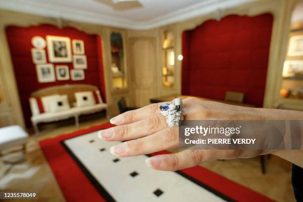 Une vendeuse présente, le 19 juin 2002, dans le salon confidentiel Jeanne Toussain de la boutique Cartier rue de la Paix, une bague Habana or gris et...