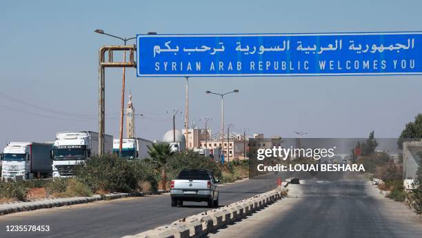Trucks wait to exit Syria at the Nassib/Jaber border post with Jordan on the day of its reopening, on September 29 after two months of closure due to...