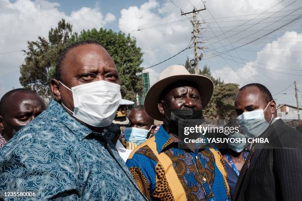 Kenya's President Uhuru Kenyatta and Kenya's opposition leader Raila Odinga stand together after attending an inauguration of Kibra Level 3 hospital...