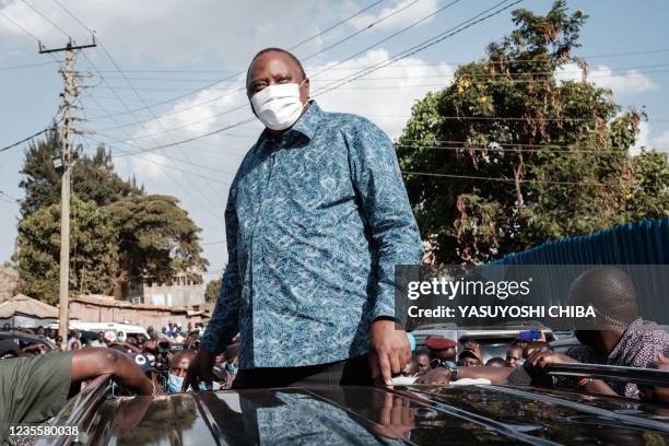 Kenya's President Uhuru Kenyatta listens to the speech of Kenya's opposition leader Raila Odinga after attending an inauguration of Kibra Level 3...