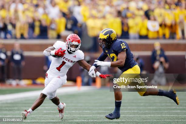 Rutgers Scarlet Knights running back Isaih Pacheco tries to fend off a tackle attempt by Michigan Wolverines linebacker Josh Ross during a college...