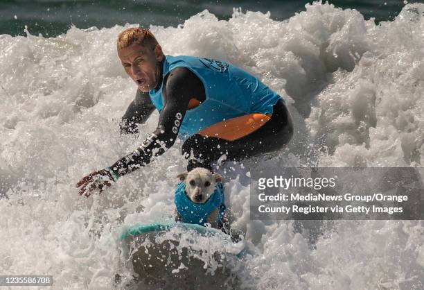 Ryan Rustan catches a wave with Sugar during the dog/human heat at the 2021 Surf City Surf Dog contest. Dozens of canines competed in Huntington...