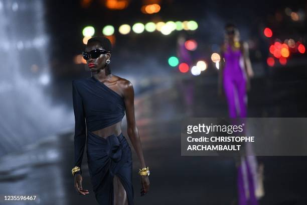 Models present creations by Saint Laurent by the Eiffel tower during the Paris Fashion Week Spring Summer 2022 collection shows in Paris on September...