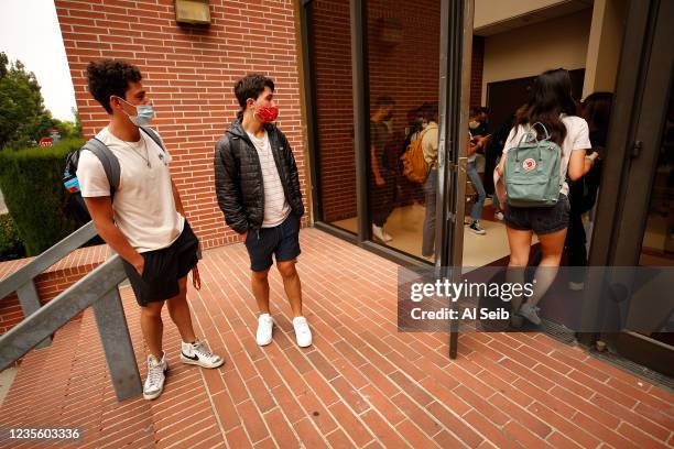 Brothers Ryan, left, and Evan Abdollahi, right, from Orange County wait to enter their first class and visit with classmates they have only seen...