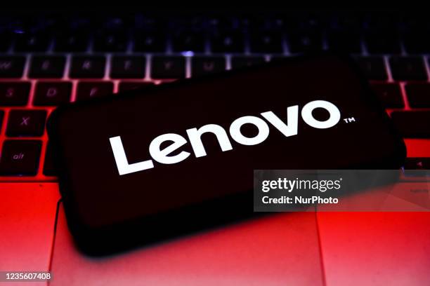 Lenovo logo displayed on a phone screen and laptop keyboard are seen in this illustration photo taken in Krakow, Poland on September 30, 2021.